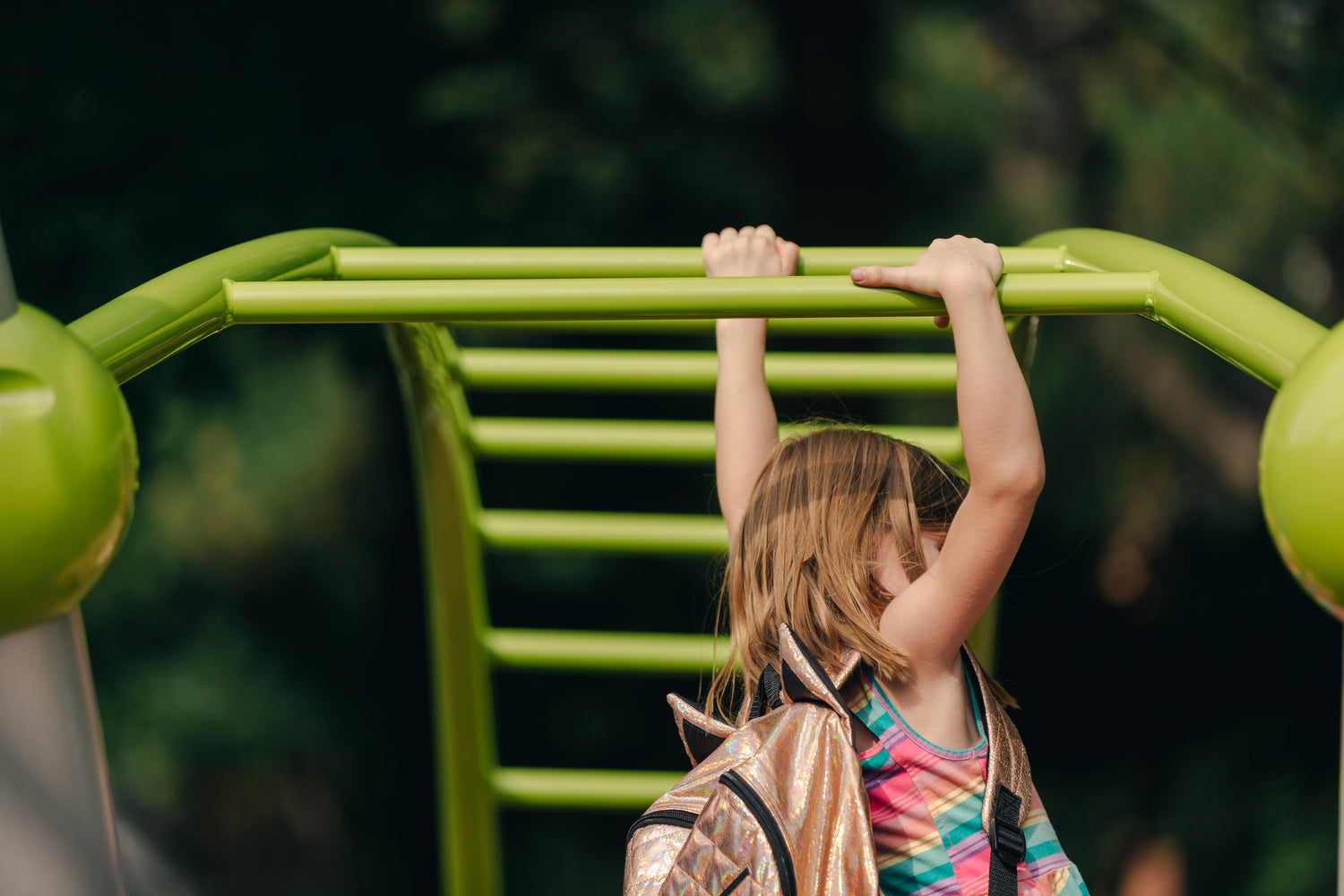 A girl swinging on bars.